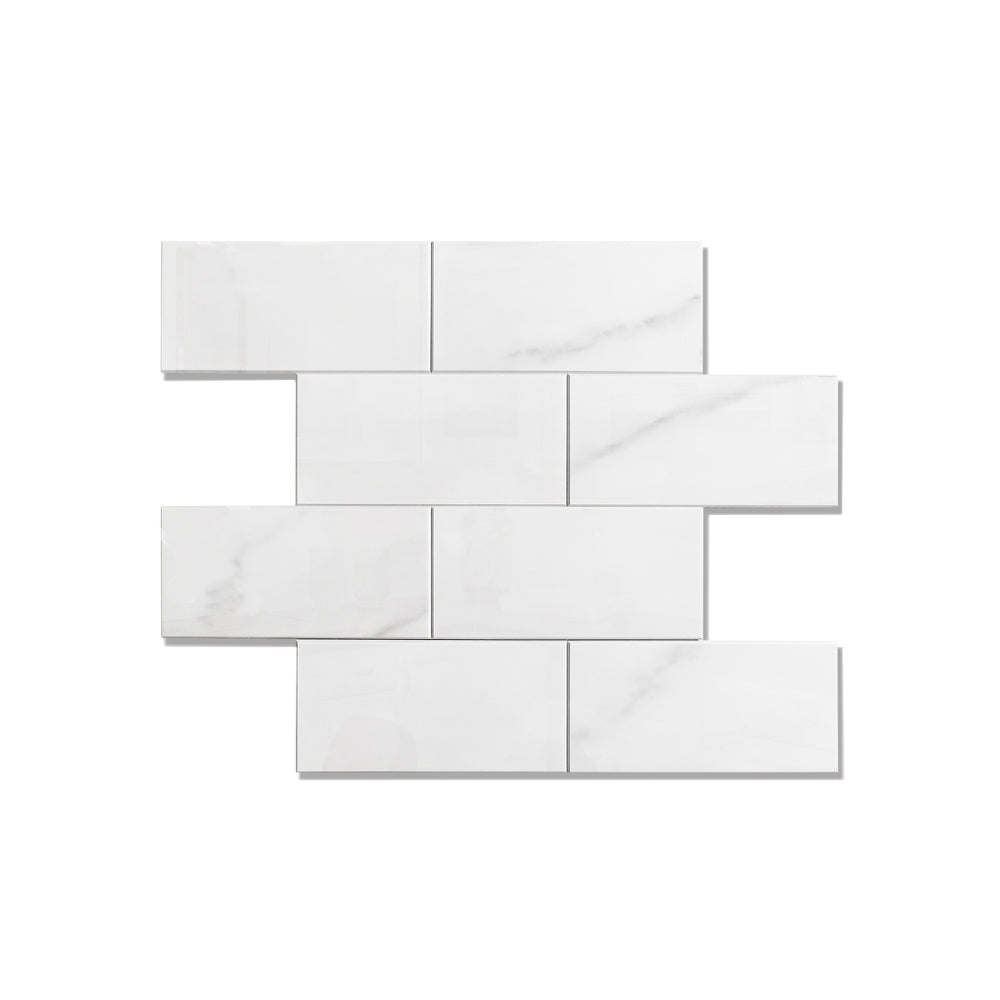 White bathroom faucet on a white vanity with candles and a plant in the background