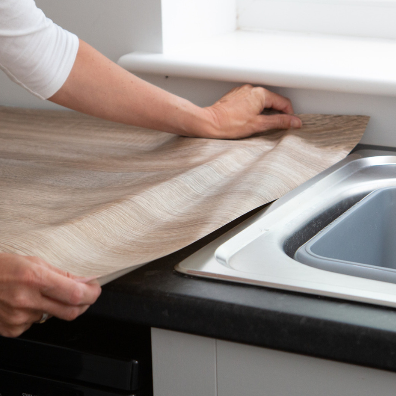 Adhesive vinyl being applied to a benchtop