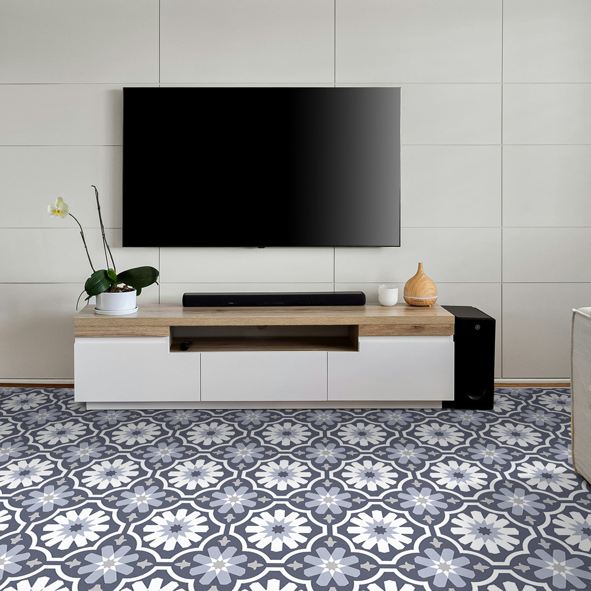 Modern living room with a television mounted on the wall above a wooden entertainment console and blue tiled floor.