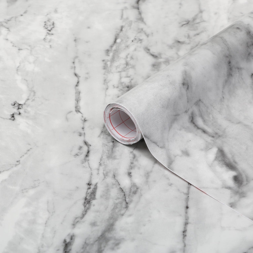 Roll of marble-patterned paper on a marble surface
