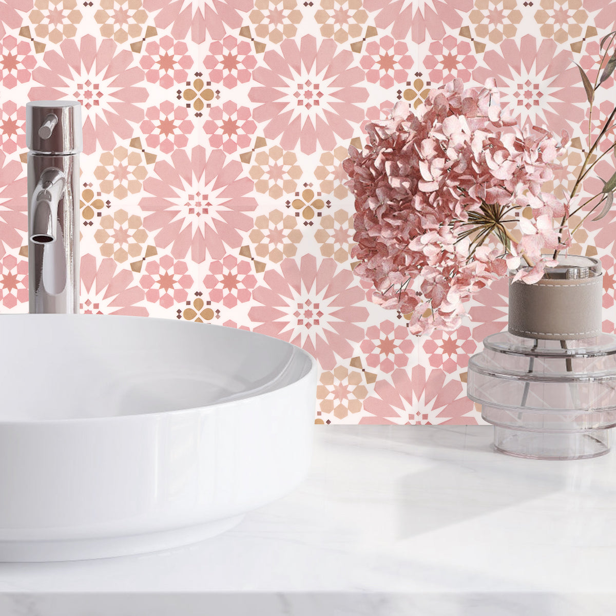 Bathroom with pink floral wall tiles white sink, and decorative vase.