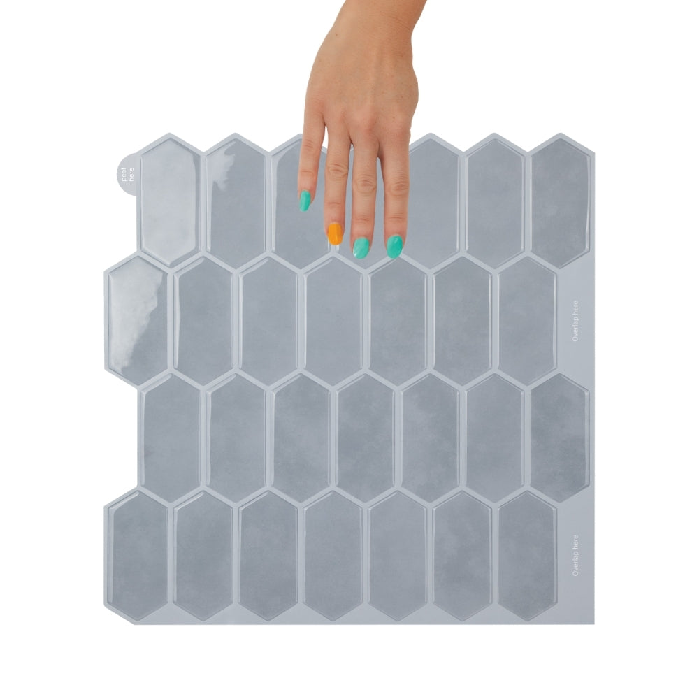 Bathroom with a white freestanding bathtub against a blue wall with geometric pattern