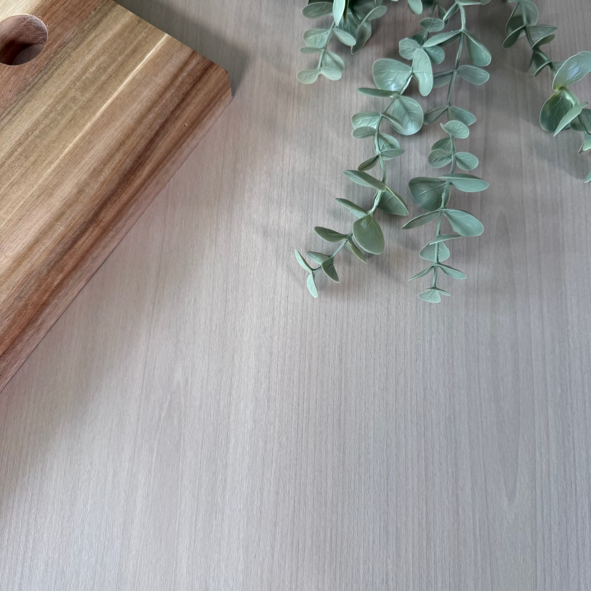 Green leaves on a light wooden adhesive vinyl surface