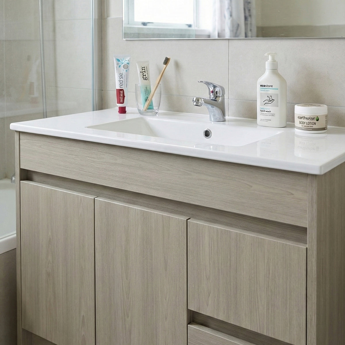 Bathroom vanity wrapped with architectural grade vinyl with sink, toiletries, and a mirror.