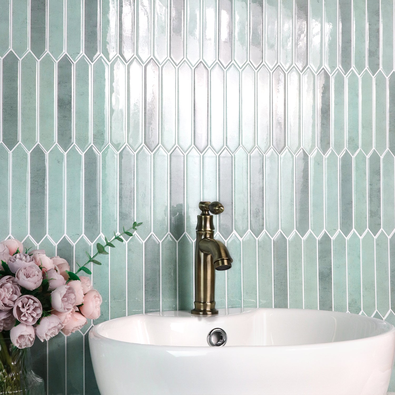 Bathroom sink with brass faucet against a tiled wall