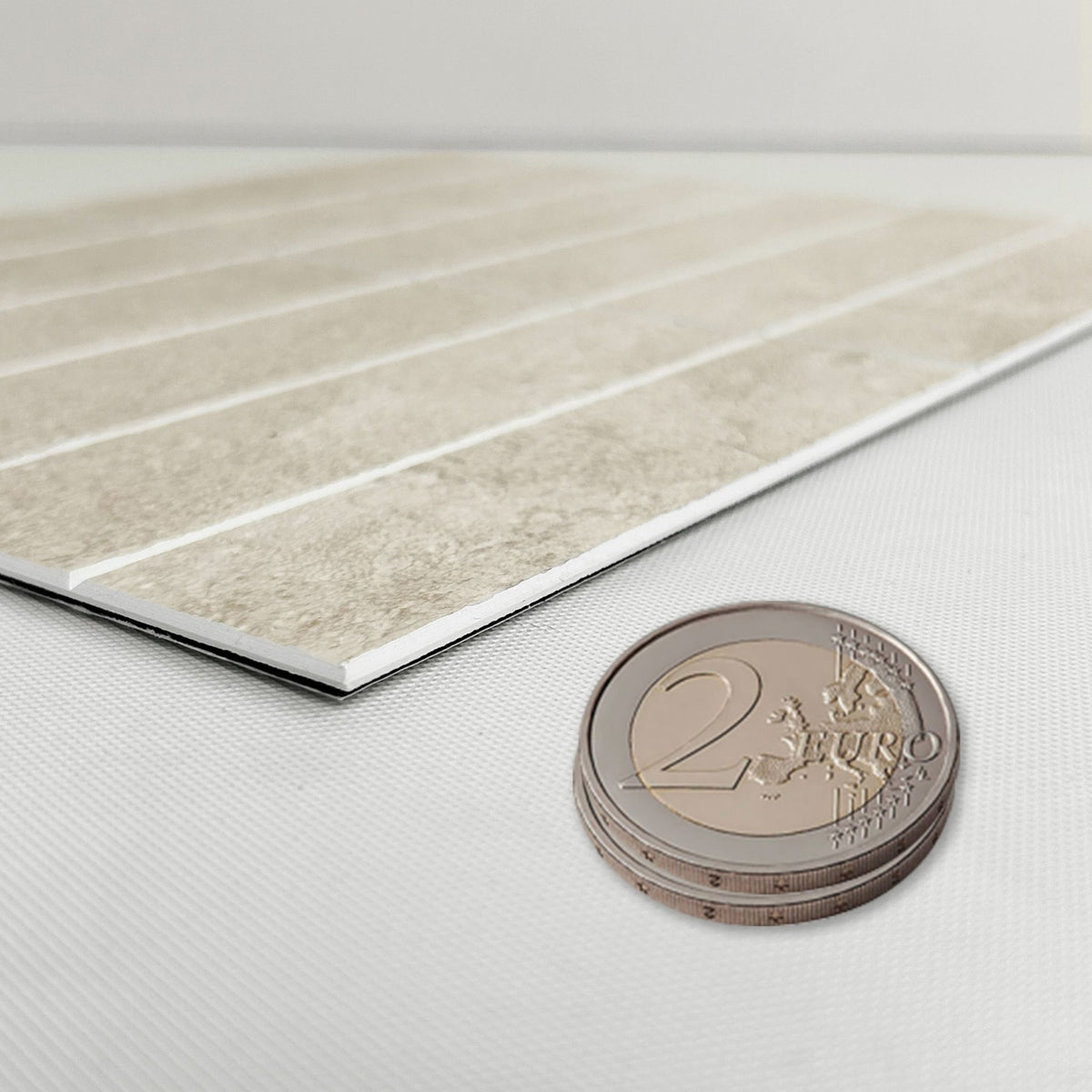 beige composite tile in a profile showing the same thickness as two Euro coins