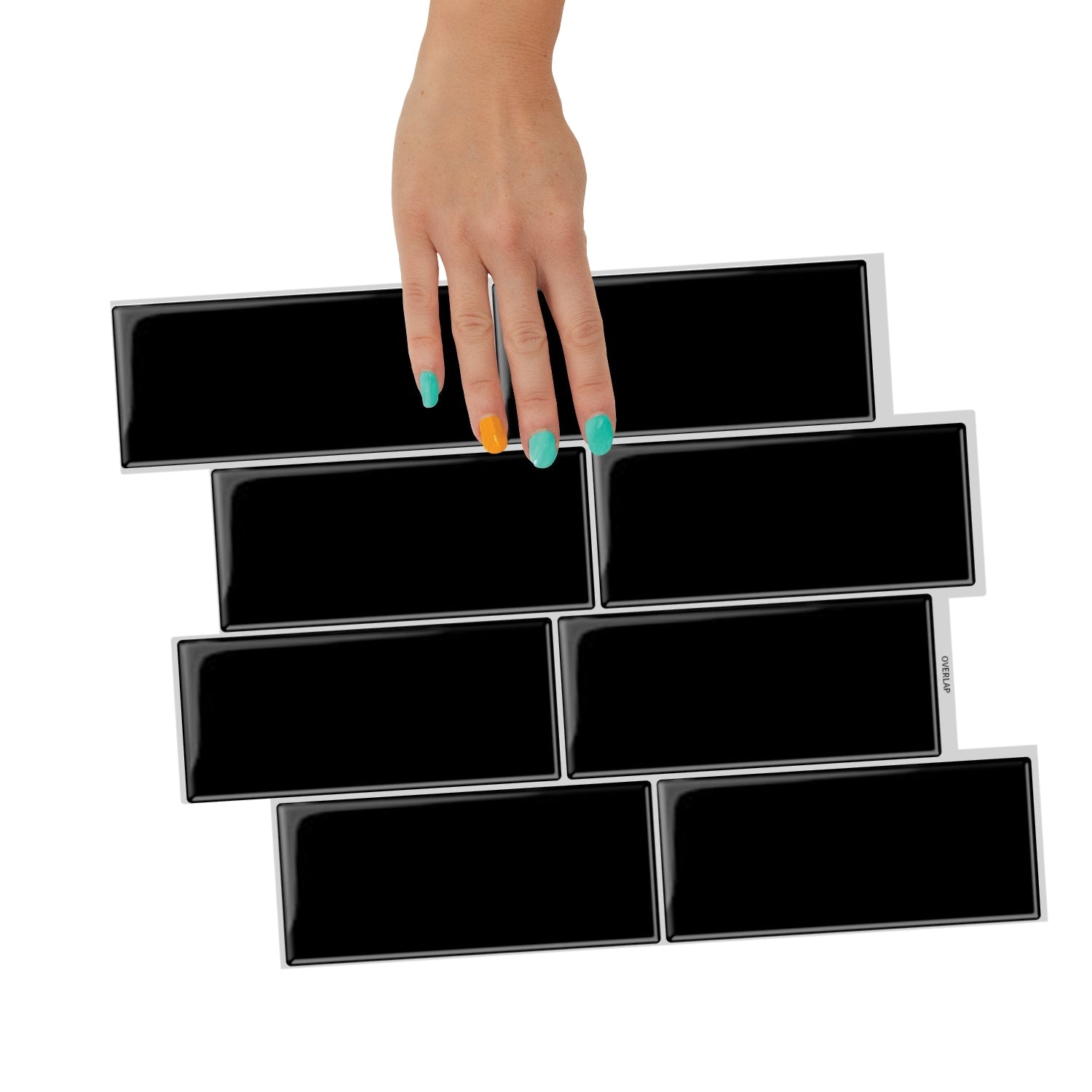 Black tiled wall with a croissant and a vase with flowers on a white surface.