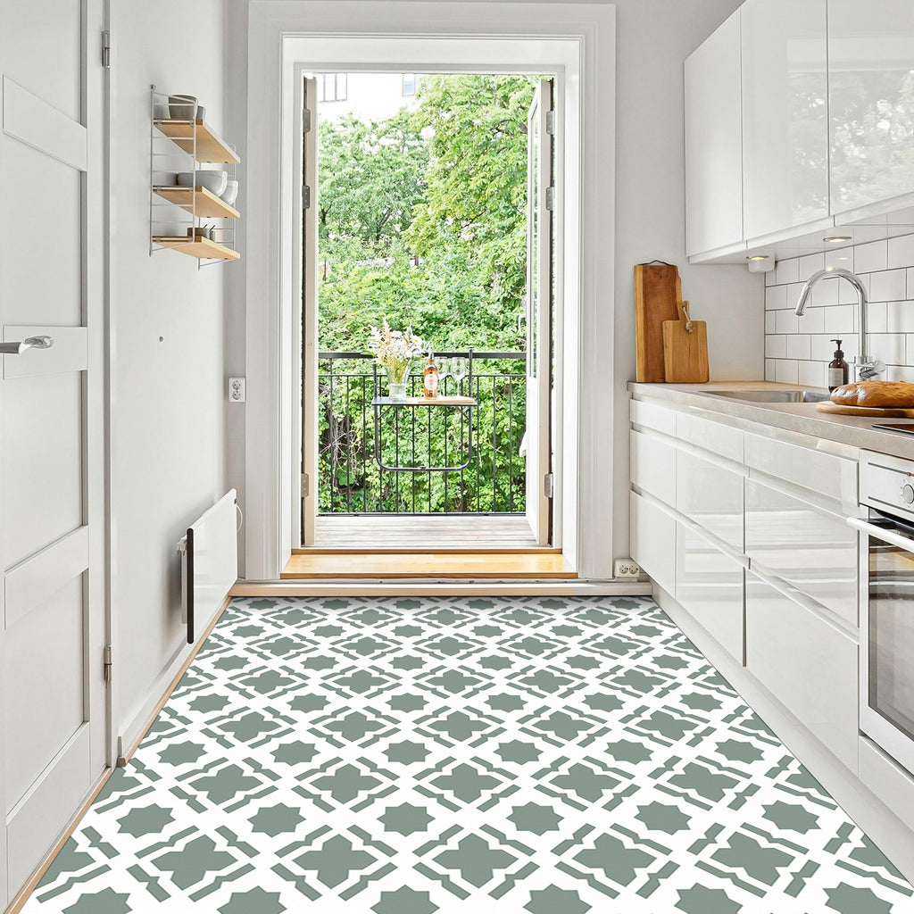 Modern kitchen with white cabinets, a patterned floor, and a view of greenery outside.