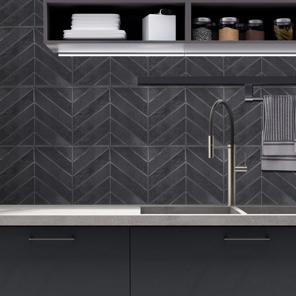 Modern kitchen with black chevron-patterned backsplash and stainless steel fixtures.