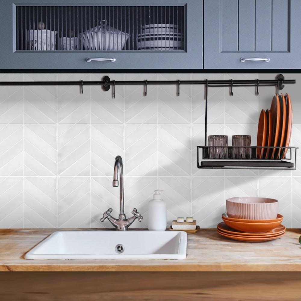 Modern kitchen with white sink, wooden countertop, and tiled chevron wall.