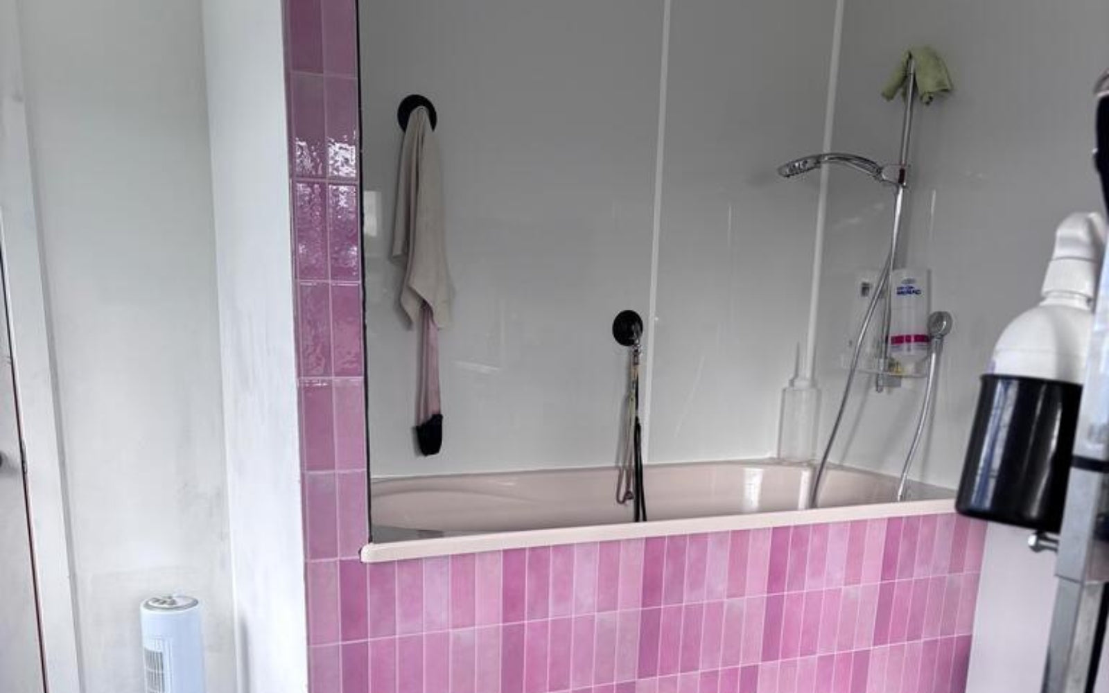 Bathroom with pink tiles on the bathtub.