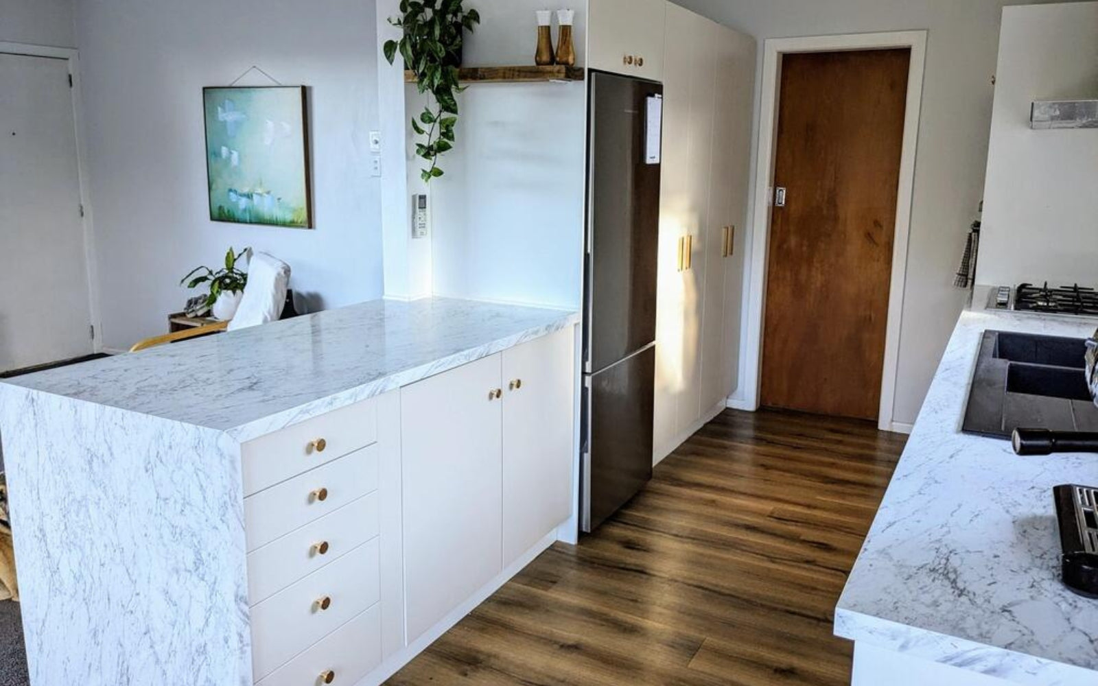 Modern kitchen with marble island and stainless and sand matte vinyl wrapped cabinetry