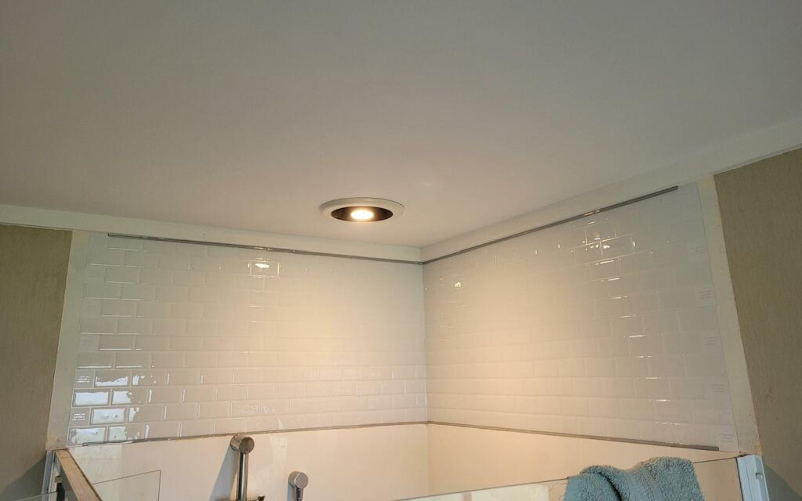 Customer photo of white subway tiles above a shower