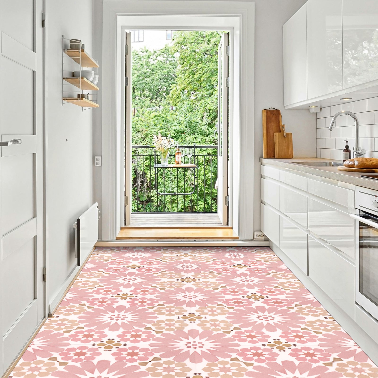 Kitchen with pink floral tiles, white cabinets, and a view of greenery outside.
