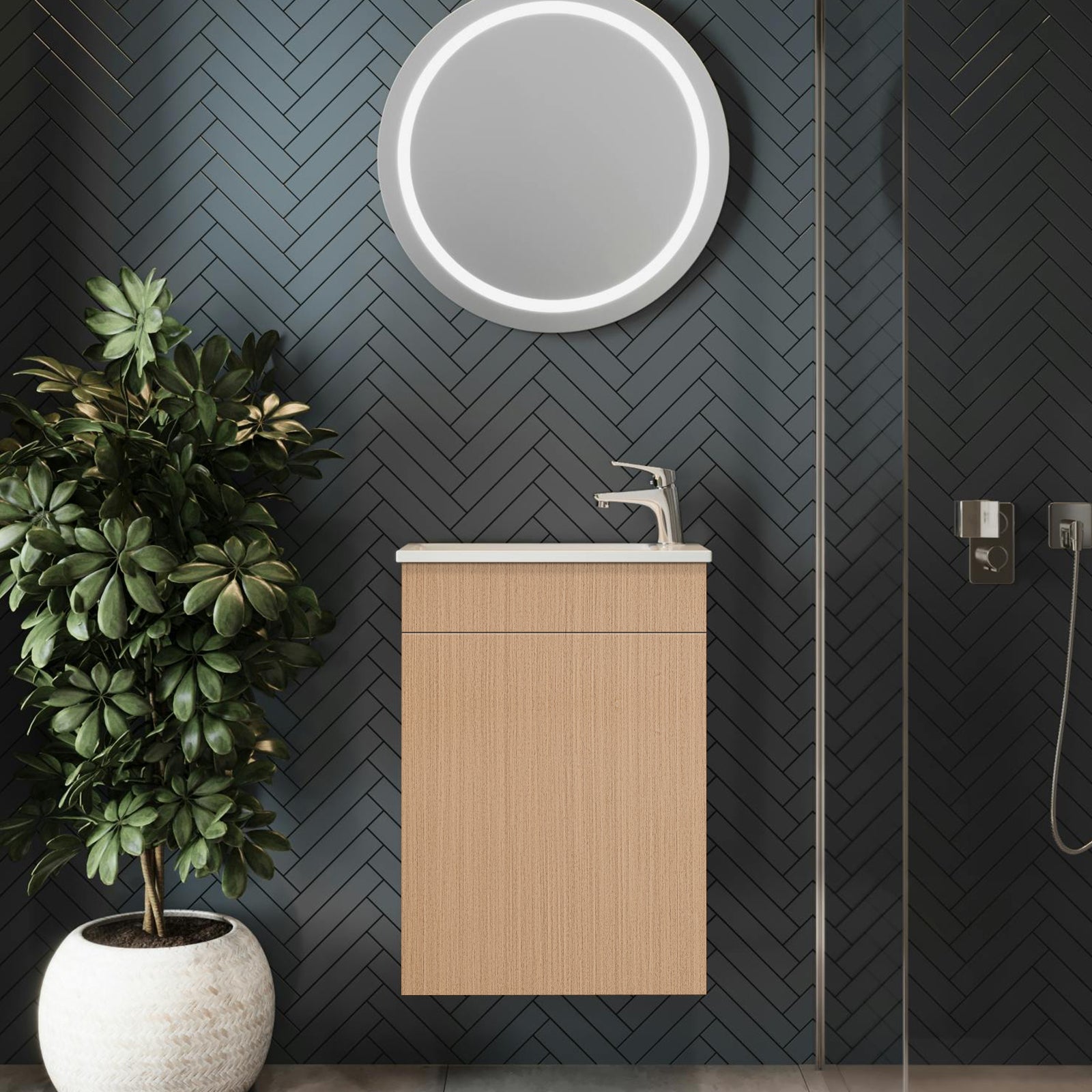 Bathroom with wooden vanity, round mirror, and potted plant against a dark wall.