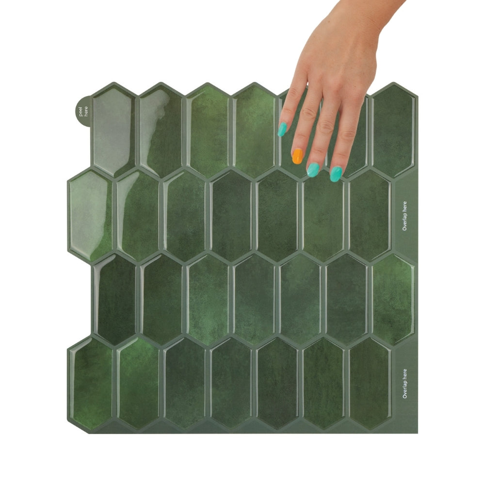 Bathroom vanity with a white sink, green tiled wall, and decorative items.