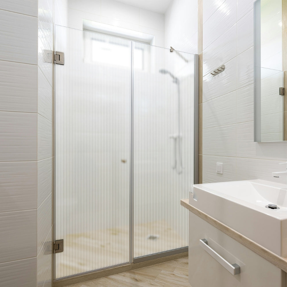Modern bathroom with shower enclosure with fluted window film and sink vanity