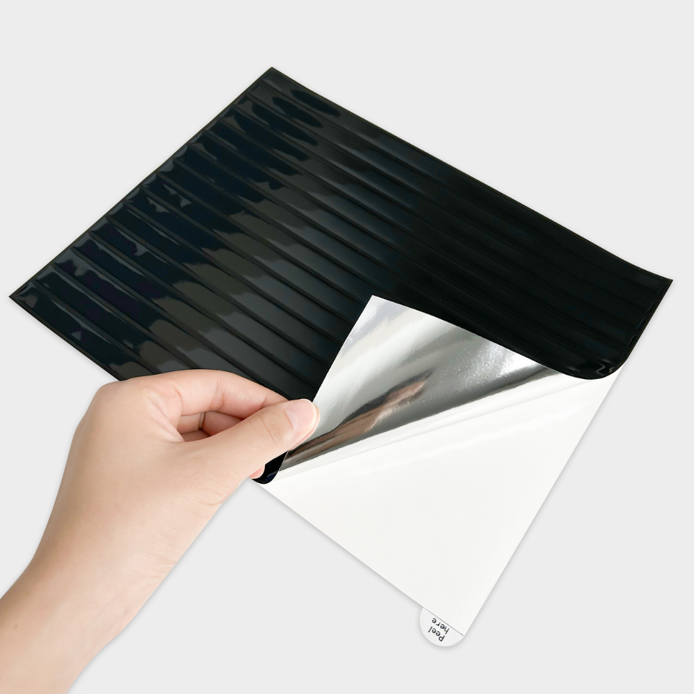 Hand peeling a black reeded tile