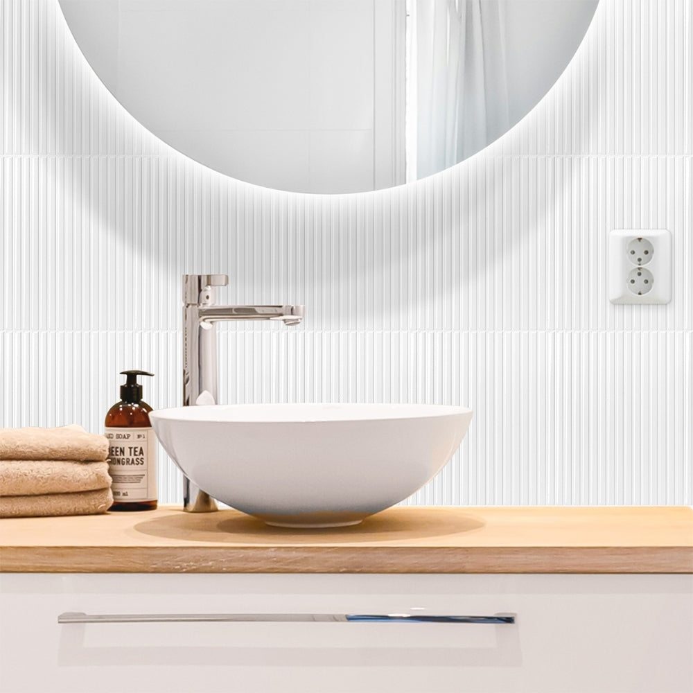 Bathroom vanity with a round mirror, sink, and toiletries.
