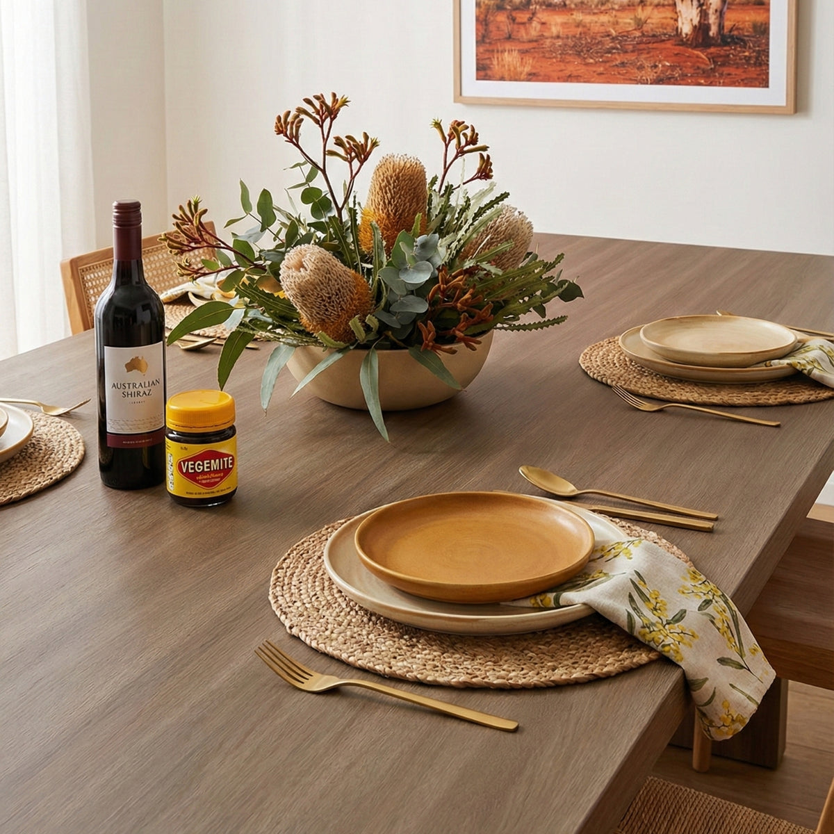 Dining table vinyl wrapped with oak wood grain set with wine, jam, and a floral arrangement in a home setting.