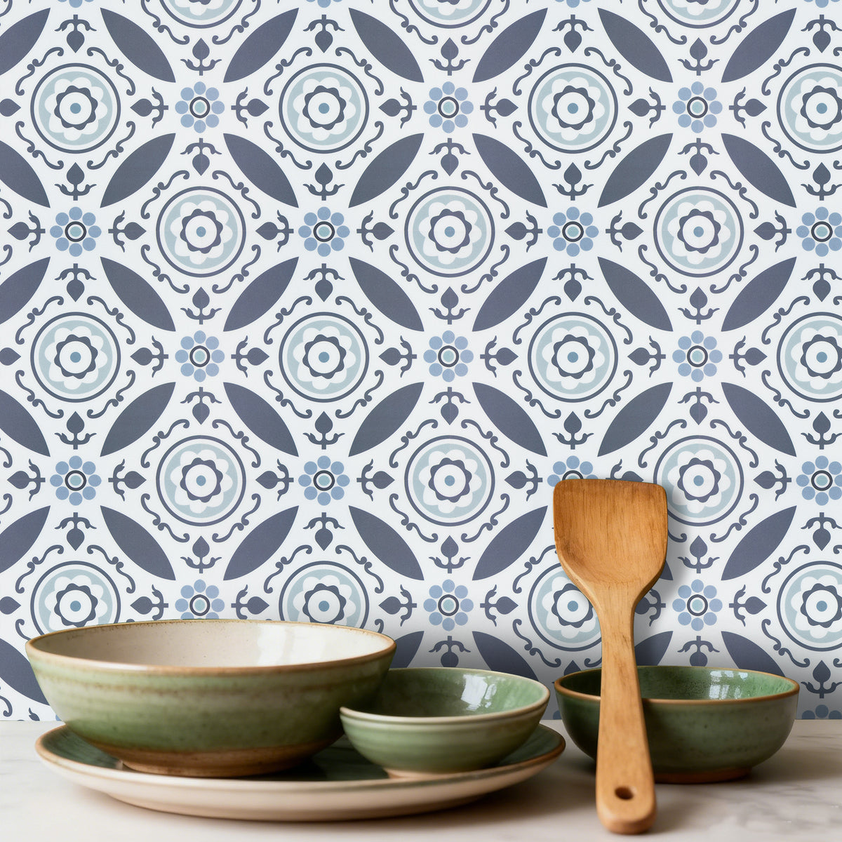 Decorative bowls and a wooden spoon against a patterned wall.