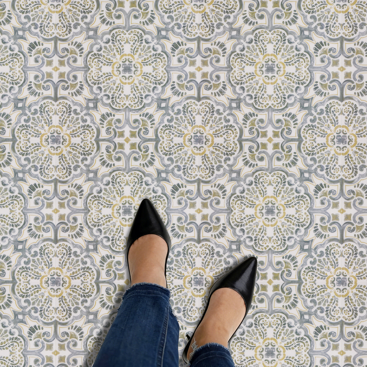 Black pointed-toe shoes on a patterned floor