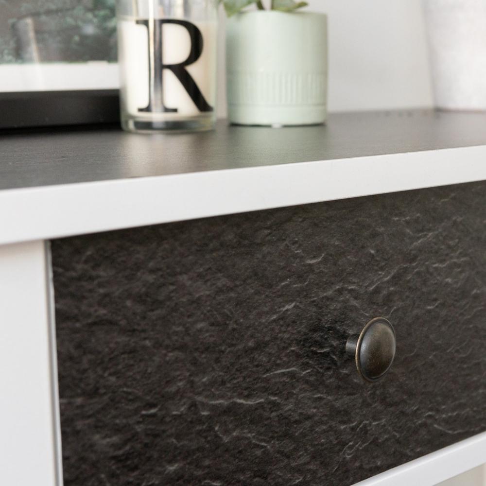 A close-up image of a drawer wrapped in slate matte adhesive vinyl with a textured appearance, placed in a white furniture piece.