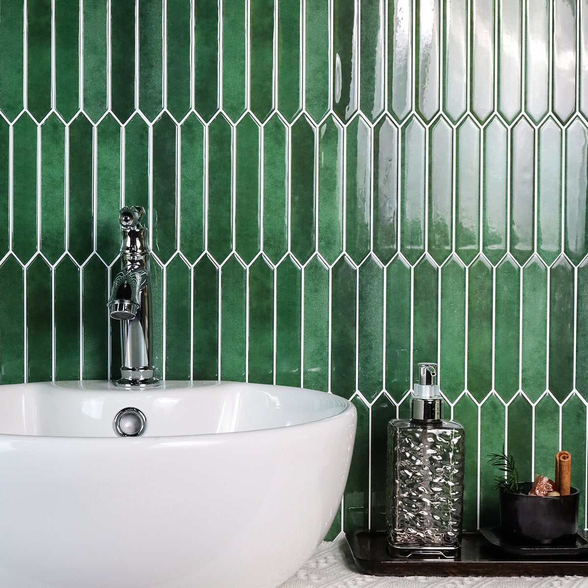Bathroom with green tiled wall, white bathtub, and decorative elements.