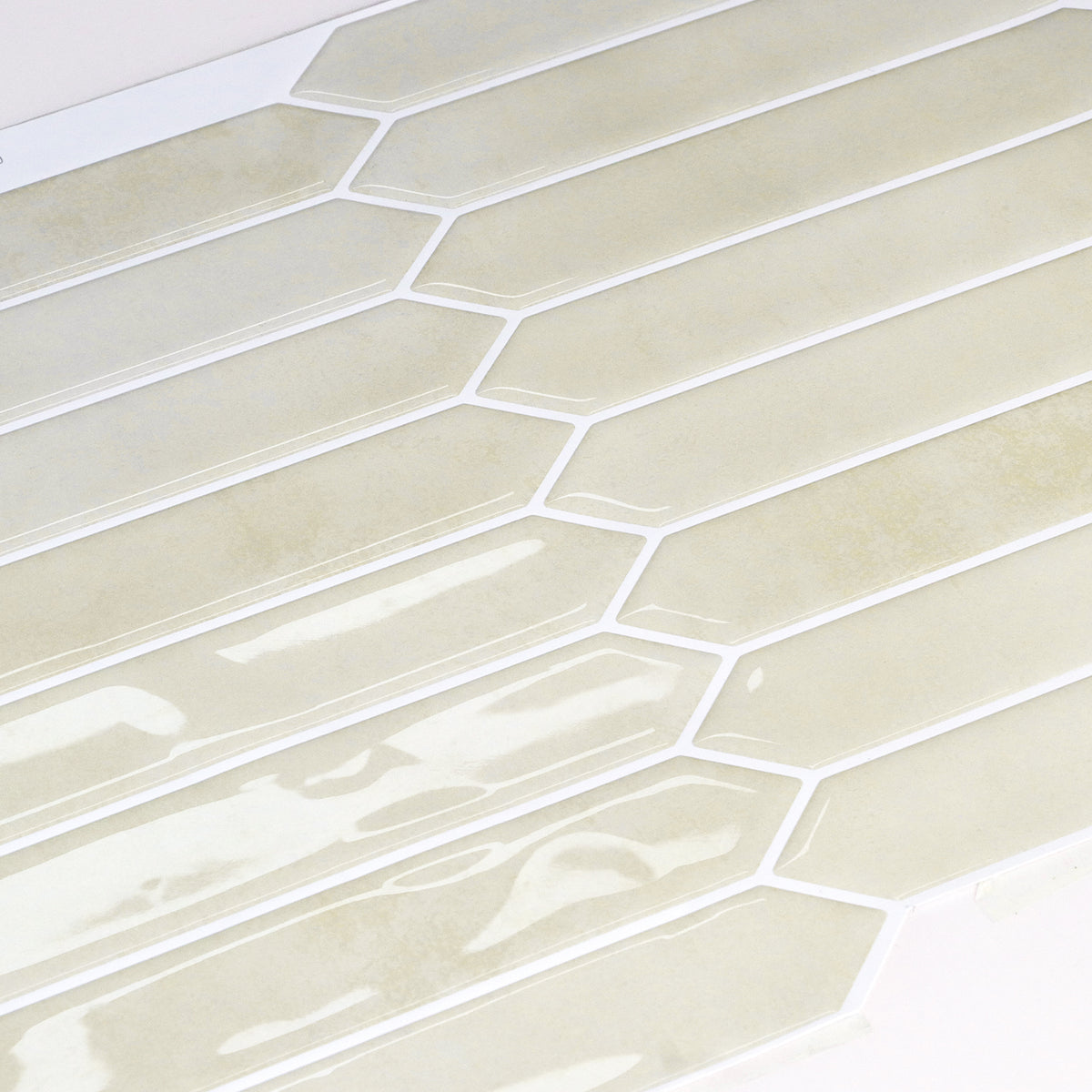 Close-up of beige hexagonal tiles with white grout on a white background