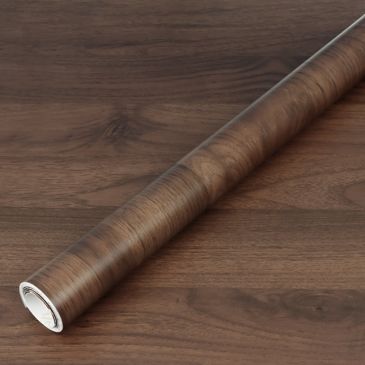 Roll of brown vinyl wallpaper on a wooden surface
