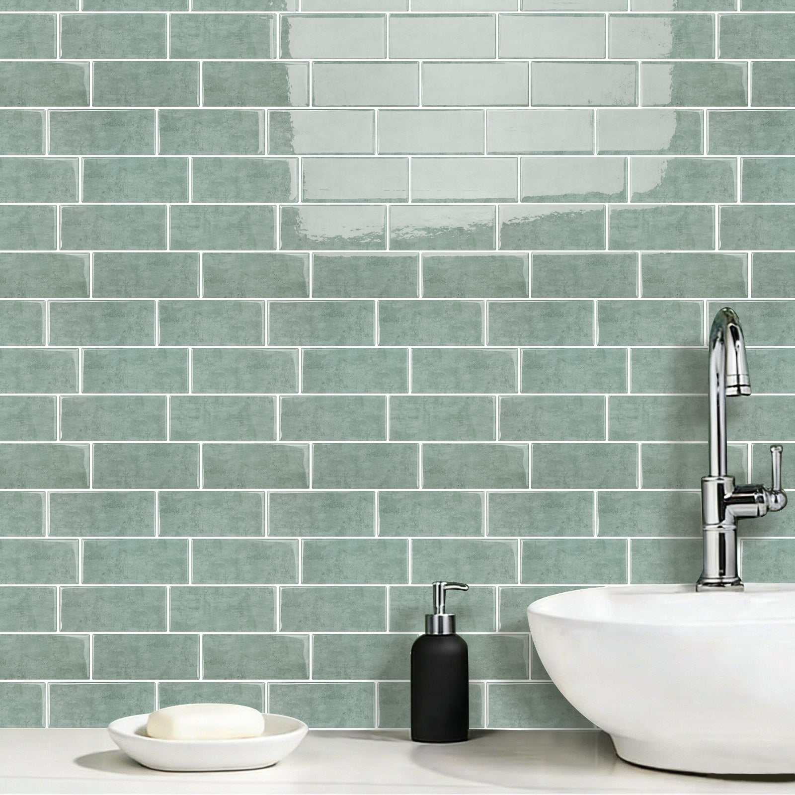 Bathroom with green tiled wall, white sink, and black soap dispenser.