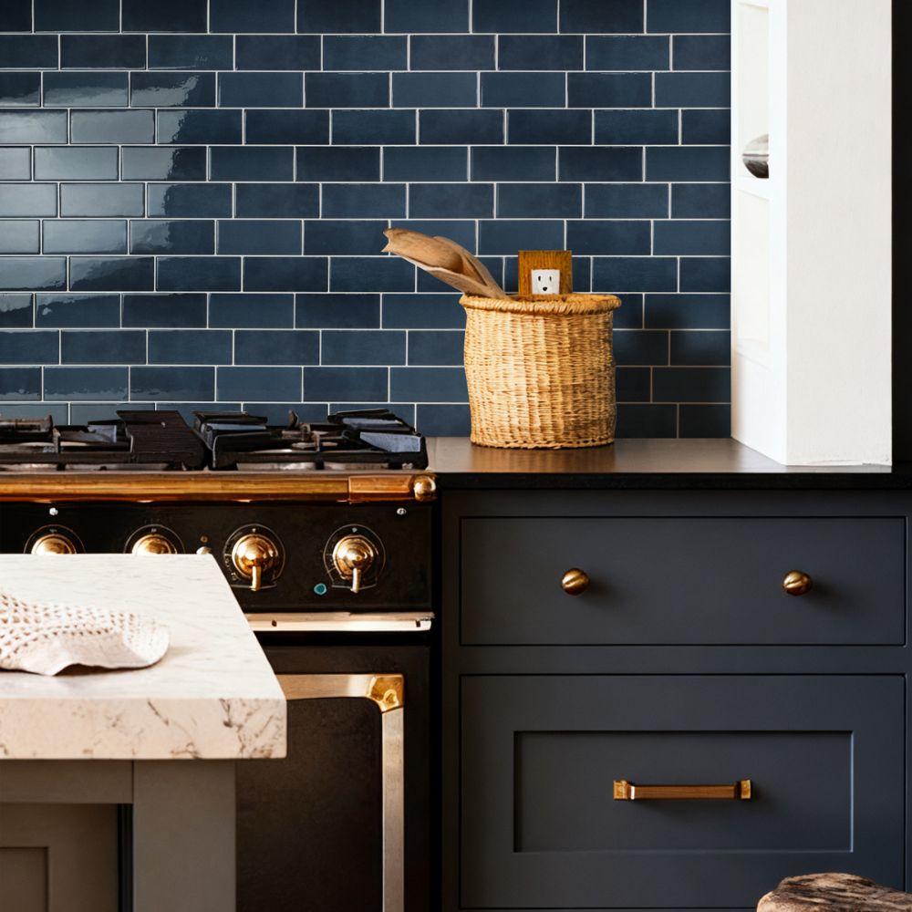 Modern kitchen with dark blue tiled wall, wooden countertop, and black appliances.