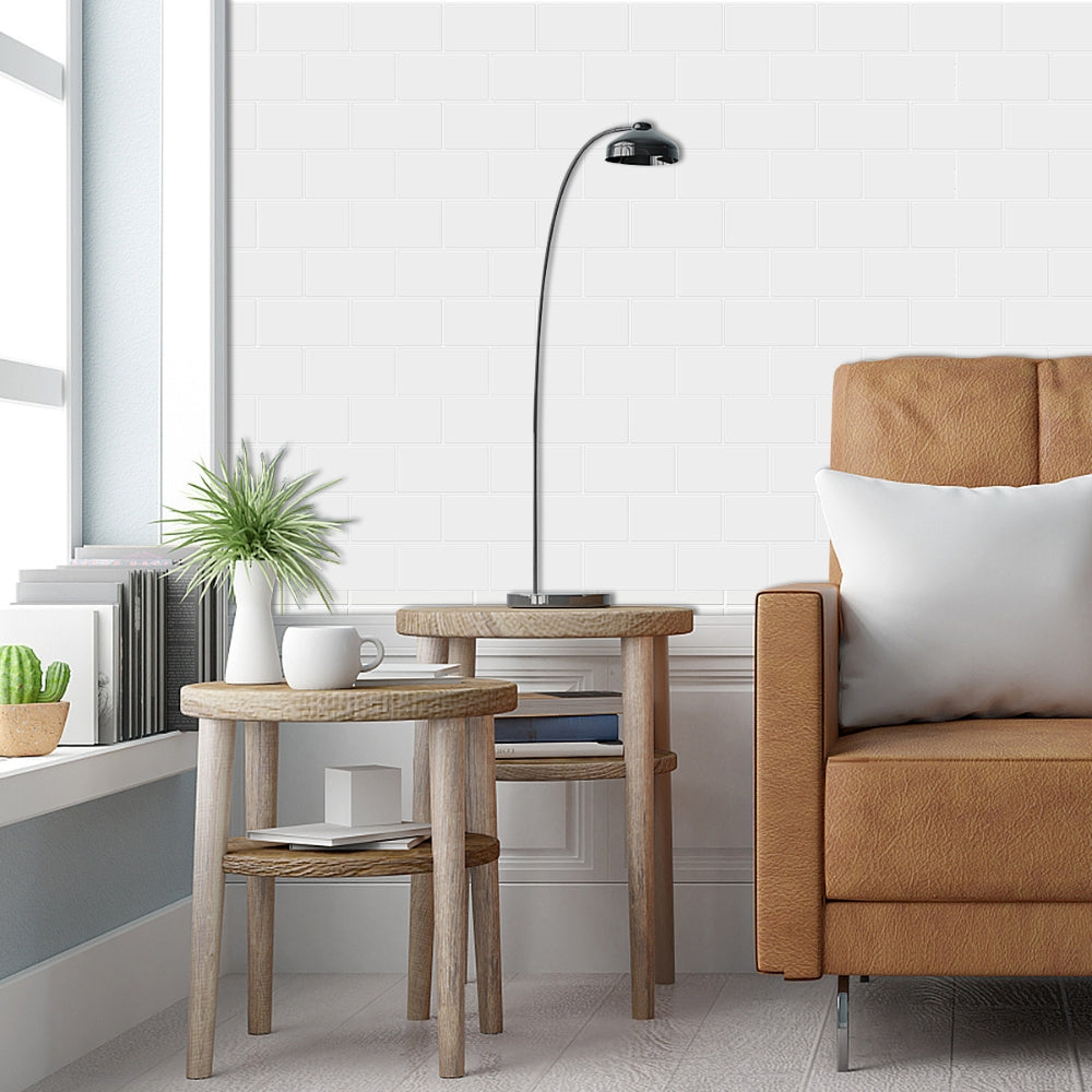 Modern living room with brown sofa, wooden side table, and floor lamp with white subway tiled wall