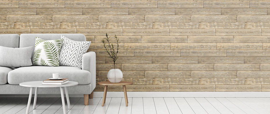 grey couch to the left and two side tables in front of a wall with distressed wood waterproof wallpaper and white floor planks