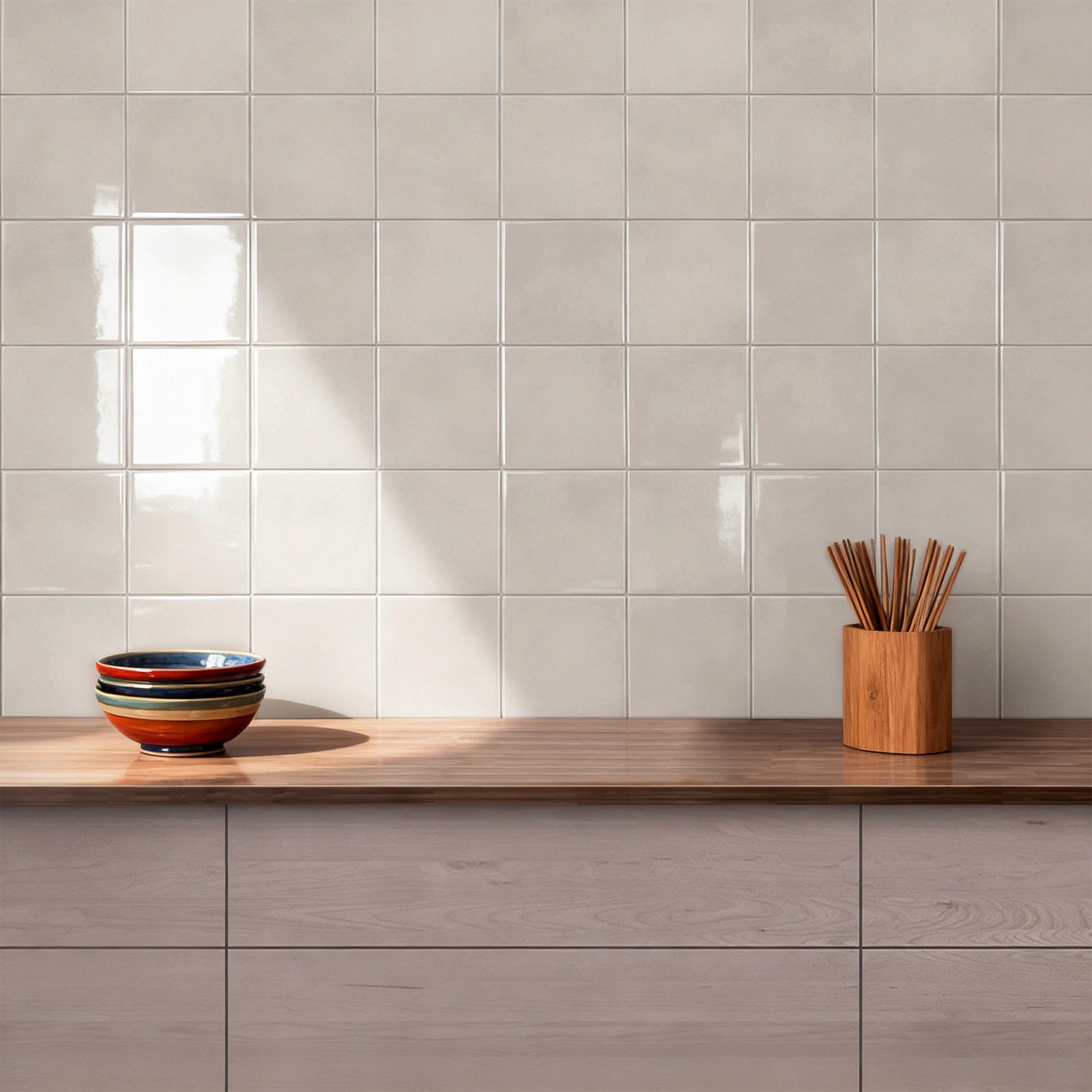 Kitchen counter with bowls and a wooden container against a sandy stone tiled wall.