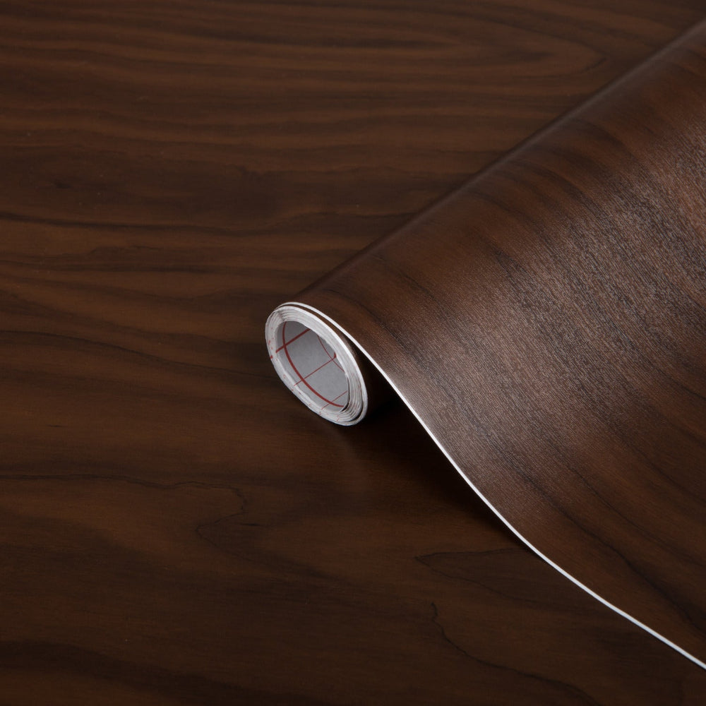 Roll of dark wood finish vinyl on a wooden surface