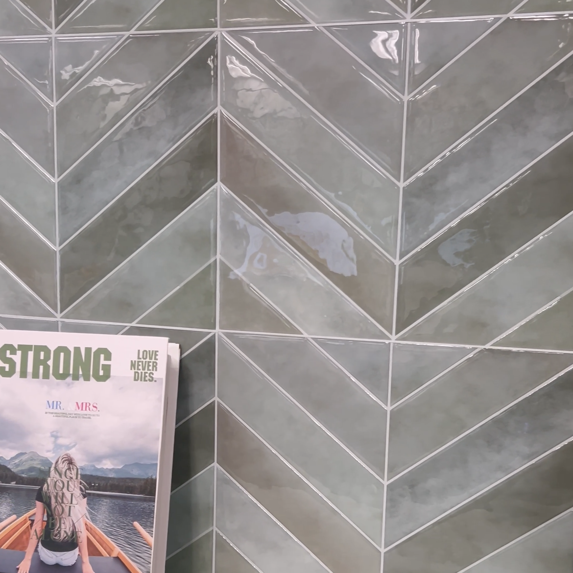 Magazine titled 'STRONG' on a surface with a tiled wall in the background