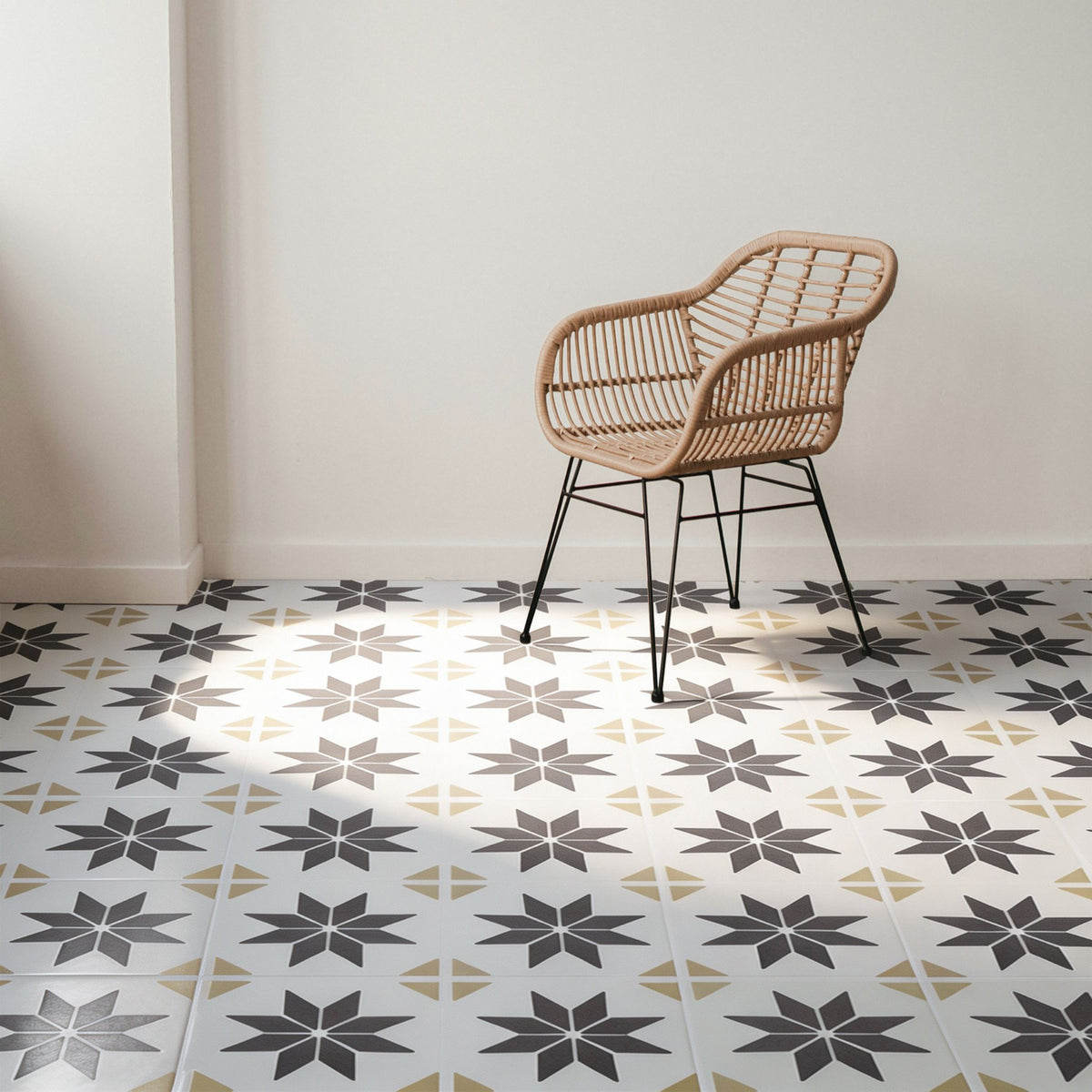 Brown and cream star patterned floor tile with a rottan chair