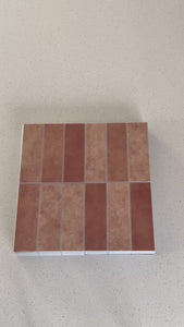 Stacked subway burnt orange matte composite tiles being shown