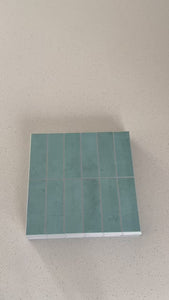Stacked subway distressed teal gloss composite tiles being shown