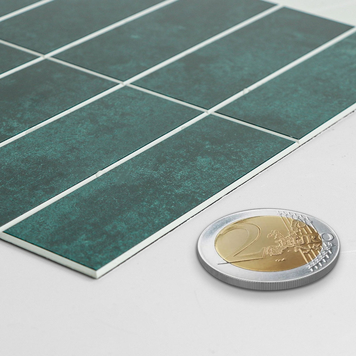 Dark green tiles sheet in a profile showing the same thickness as a 2 Euro coin