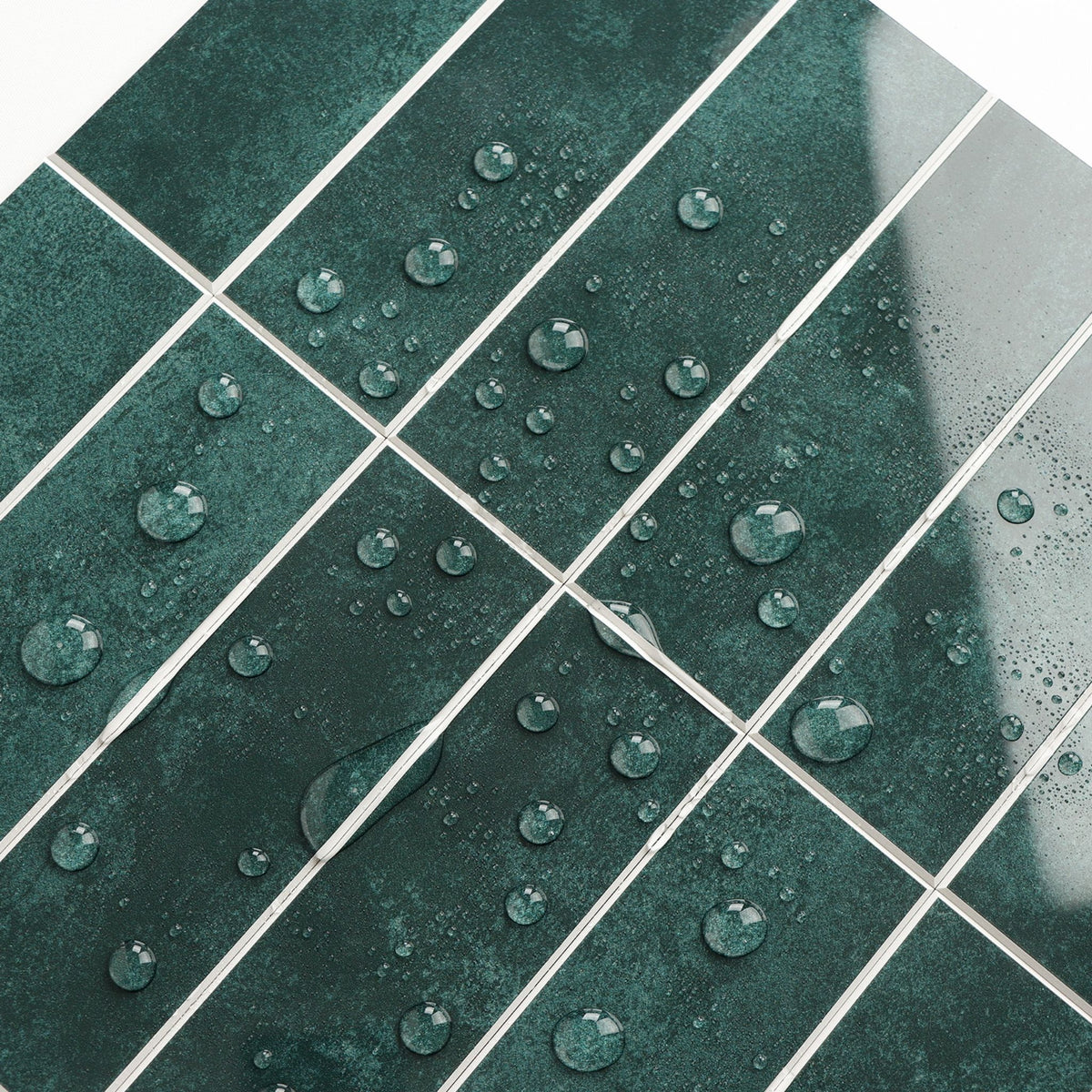 Dark green glossy rectangular tiles with white grout lines and water droplets on the surface.