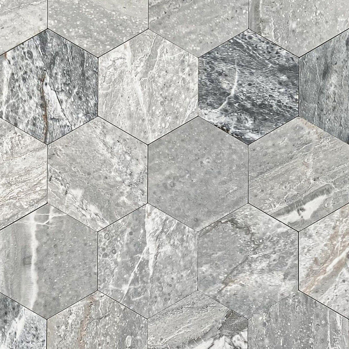 Grey marble hexagonal mosaic tile pattern with natural stone veining and varying light and dark grey tones.